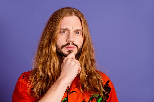 Photo of gloomy minded pensive person with beard long hairstyle dressed print shirt hold arm on chin isolated on violet color background.