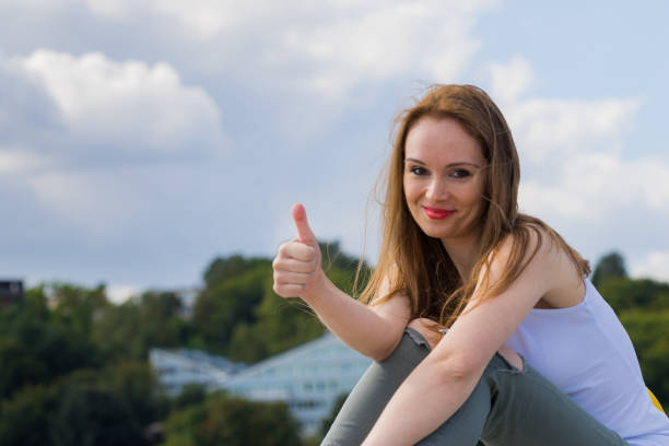 istock Girl relaxing outdoor give thumb up 2012504615