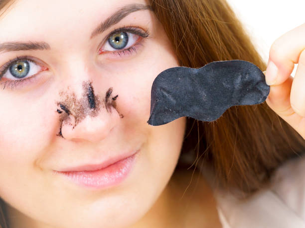 istock Woman removing pore strips mask from nose 2012558006