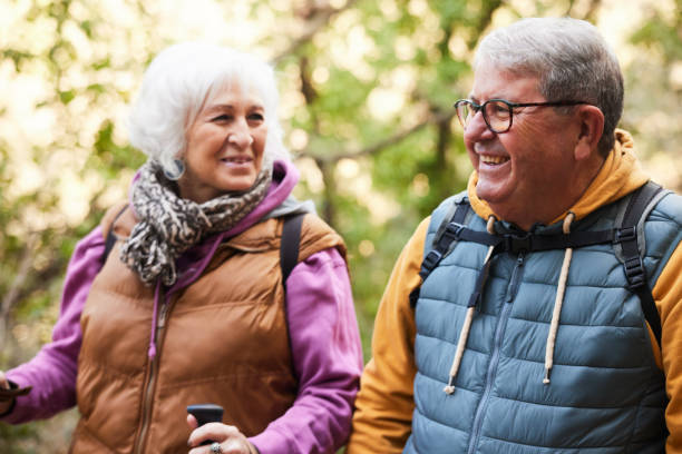istock Cheerful Banter: Gray-Haired Couple Walks Closely in Autumn Forest 2012561279