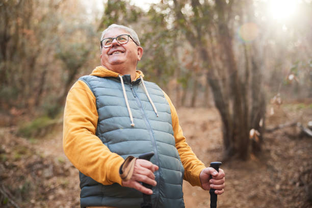 istock Joyful Hiker: Smiling Man Poses with Hiking Poles Looking Up. 2012562472