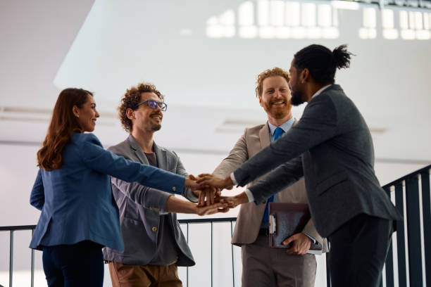 istock Happy multiracial business team gathering their hands in unity in the office. 2012564147