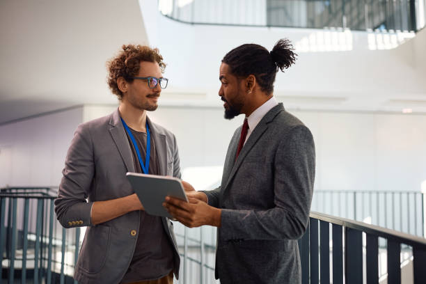 istock Diverse businessmen talking while working on digital tablet in the office. 2012564719