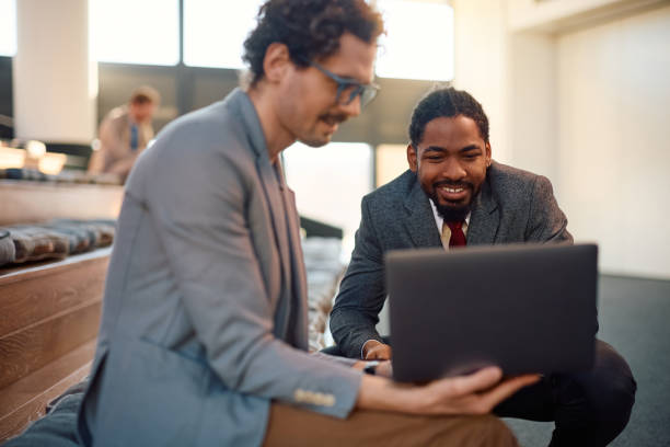 istock Happy businessmen working on laptop in board room. 2012565827