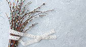 banner willow branches and cotton ribbon on grey concrete background,