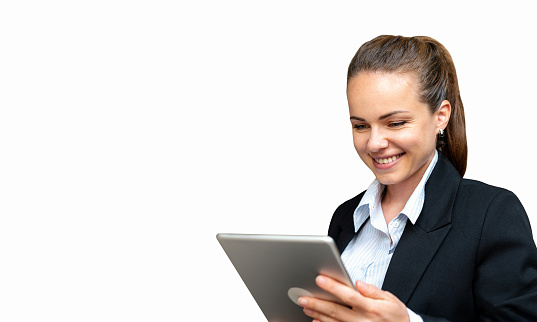 Businesswoman wearing suit works at the office uses her digital tablet and smiling.