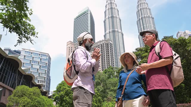 Two senior Asian tourist having a city tour through the famous Kuala Lumpur Petronas Twin Towers