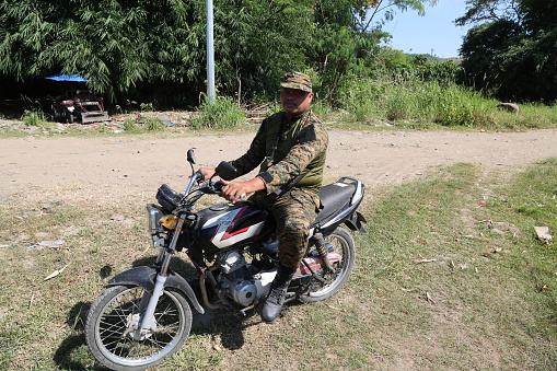Mindanao, Cotabato City - Philippines, August 12, 2019:  The primary mode of transportation for MILF guerrillas in the jungle of Cotabato is the motorbike. Along the route to Badr Camp, it's common to see many MILF members guarding villages with their motorbikes.