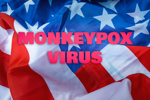 Inscription monkeypox virus on an american flag.Virus transmitted to humans from animals.The first virus cases of infection in the US.Monkeypox outbreak concept.