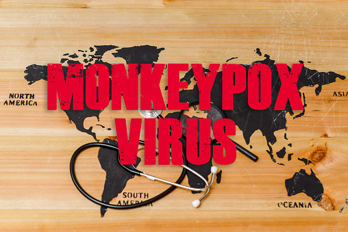 Inscription world wooden map,a stethoscope and a magnifying lip lie on the map.Monkeypox is caused by monkeypox virus.Smallpox is a viral zoonotic disease. Virus transmitted to humans from animals.