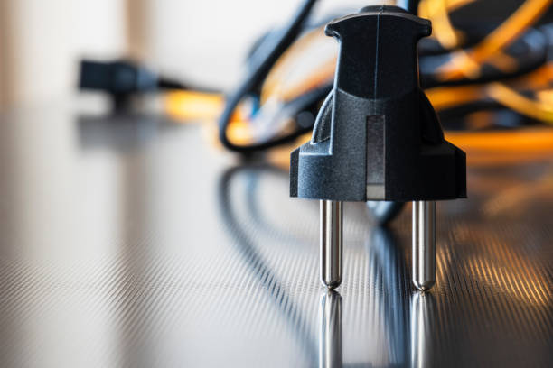 istock Electric plug with power supply cord cable on metal surface 2012614316