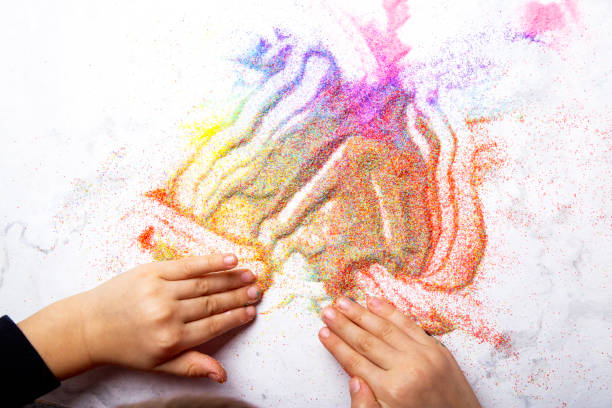 istock Child creative playing with colorful sand. Motor skills, child creativity concept. 2012624550