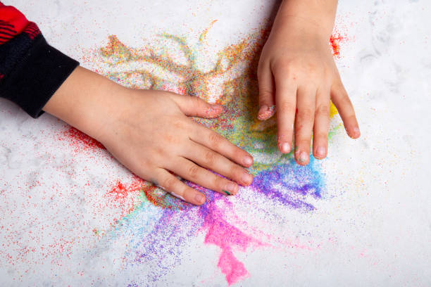 istock Kid hands with colorful sand on white background. Motor skills, child creativity concept 2012625099