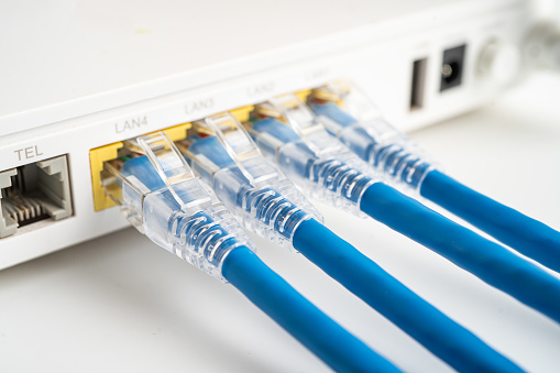 closeup image of hand plugging ethernet cable into laptop