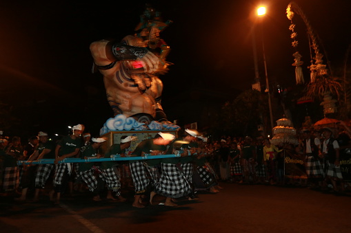 Kuta, BALI, INDONESIA - MARCH 2019: Balinese carry the ogoh-ogoh, the giant menacing-looking dolls during the ogoh-ogoh parade on the eve of Nyepi, the Balinese Hindu Day of Silence that marks the arrival of the new Saka lunar year on March 6, 2019 in Kuta, Bali, Indonesia.
