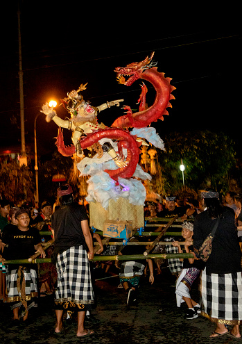 Kuta, BALI, INDONESIA - MARCH 2019: Balinese carry the ogoh-ogoh, the giant menacing-looking dolls during the ogoh-ogoh parade on the eve of Nyepi, the Balinese Hindu Day of Silence that marks the arrival of the new Saka lunar year on March 6, 2019 in Kuta, Bali, Indonesia.