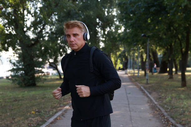 istock Mature  man walking and listen music 2012636149