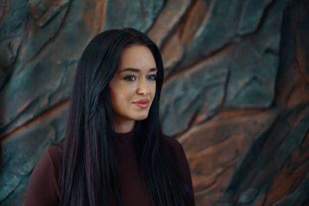 Black haired woman against the decorative textured wall