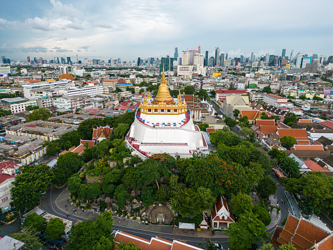 Golden mountain buddhist temple locate in Bangkok city with old ancient house building background aerial view Thailand
