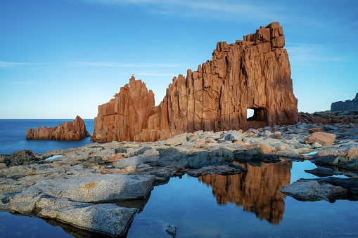 A view of the red rocks of Arbatax with reflections in tidal pools in the foreground
