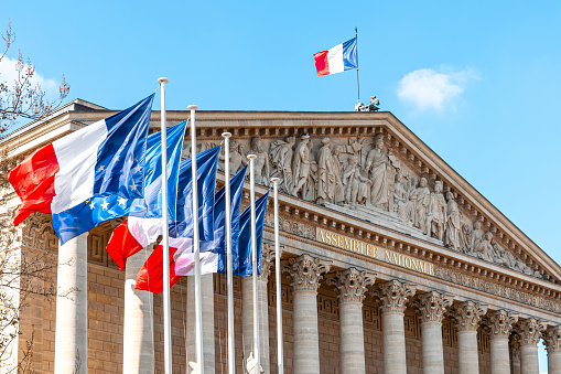 View on National Assembly building in Paris, with French and European flags flying. Paris in France.