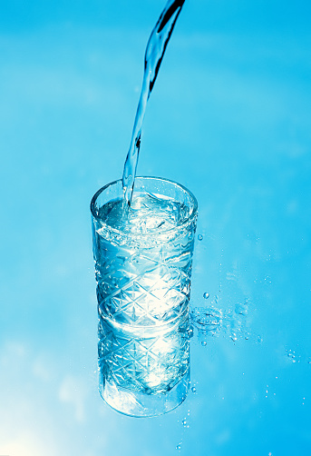 Hydration Blue water in glass with drops and splashes on transparent background. Skin hydration treatment. Blue water background. Sport concept. Clean Hydration concept. Water product