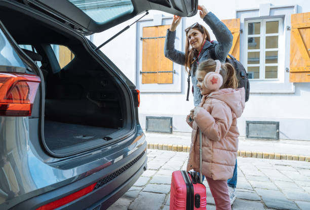 istock Daughter on road trip with mother, loading baggage in the car trunk 2012716956