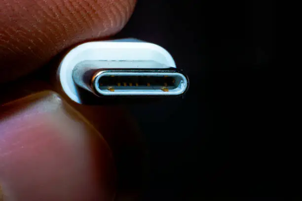 Innovative tech in hand - a close-up macro photo of holding a sleek C-type USB connector, capturing the essence of modern connectivity.
