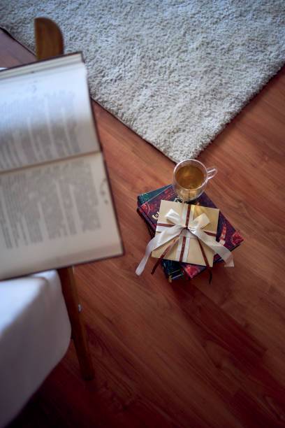 istock Gift certificate next to  perfect  place for reading and relaxing, a white armchair surrounded by books in a bright room 2012736854