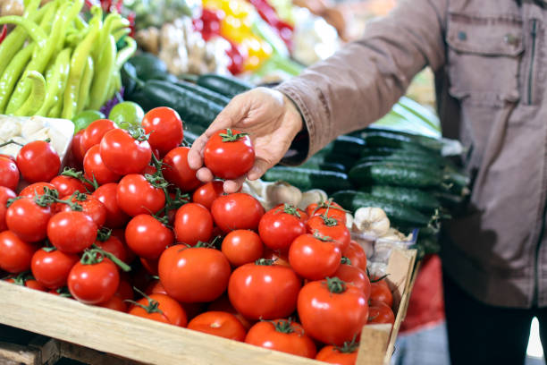 istock Buying tomatoes at a market 2012739030