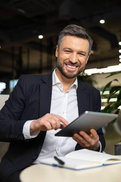 istock Positive young manager with tablet in hands working in the office 2012744055