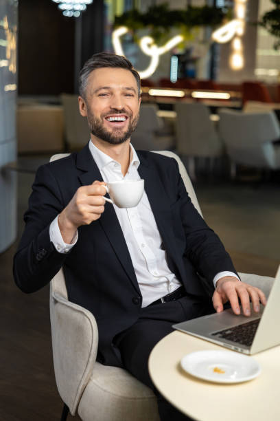 istock Young elegant businessman working in the office and having coffee 2012745817