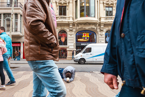 Homeless beggar man begging alms on street. Barcelona, Spain, Europe.