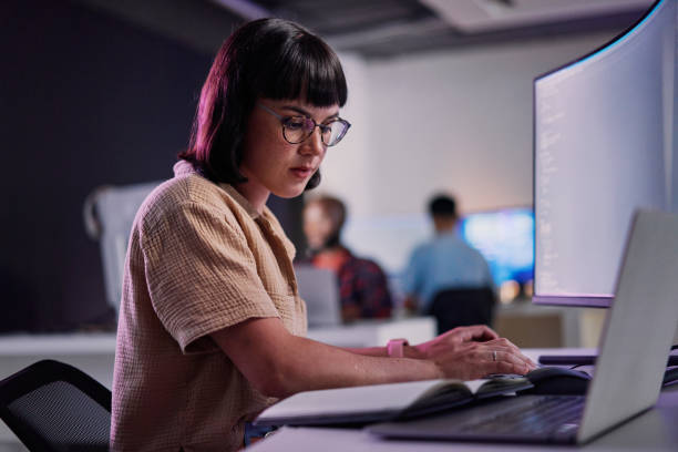 professional it worker working late, coding and machine learning working with ai. - programador imagens e fotografias de stock