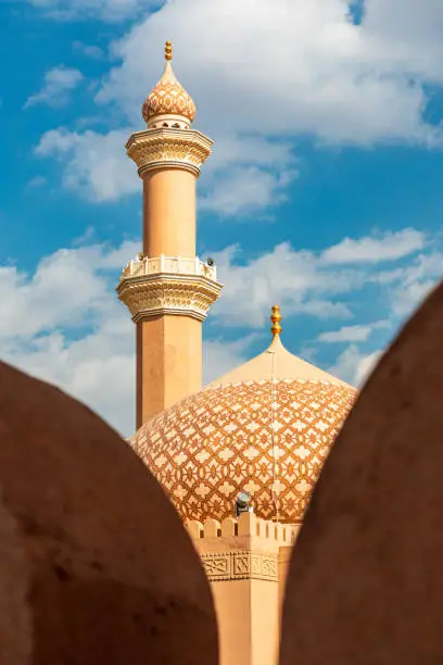Al Qala'a Mosque in Nizwa, Oman. View on mosque minaret through fort walls
