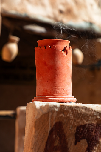 Incense burning in ceramic incense burner at arabic souk in Oman. Close up shot with focus on smoke.