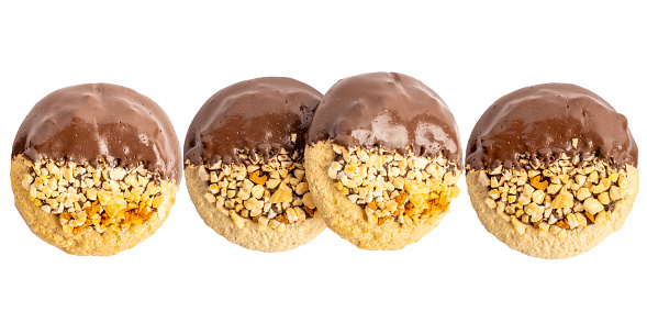 Four chocolate dipped peanut cookies in a line isolated on a white background.