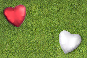 White and red heart balloons on a grass lawn