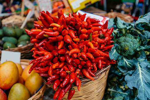 Basket full of red chili peppers on a street market in Catania, Sicily.