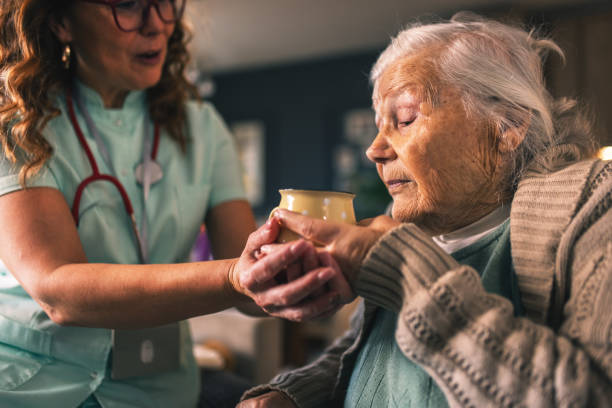 istock a nurse visits an elderly disabled woman at home and helps her 2012830347