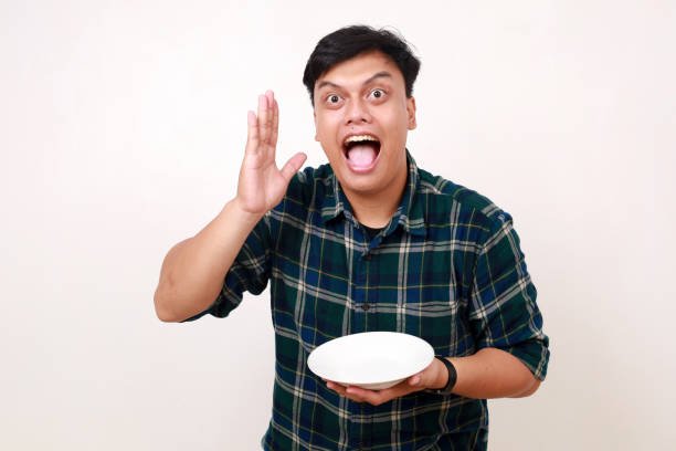 istock Excited Young asian man showing happy expression while holding an empty plate 2012831441