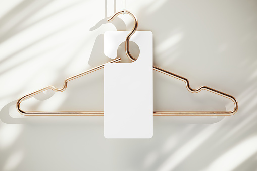 Blank advertising tag hanging on a clothing hanger mockup. 3D rendering