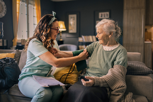 a nurse visits an elderly disabled woman at home and helps her