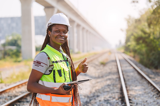 Portrait African black engineer women worker work checking service in train railway tracks construction site in transportation industry