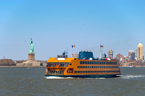 The Staten Island Ferry passing the Statue of Liberty in New York City.