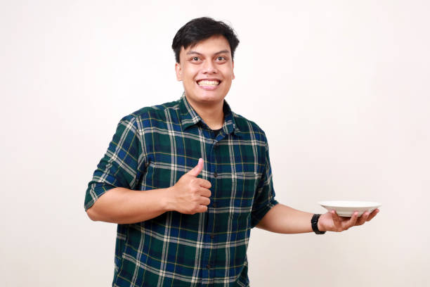 istock Excited young asian man holding empty plate 2012853092