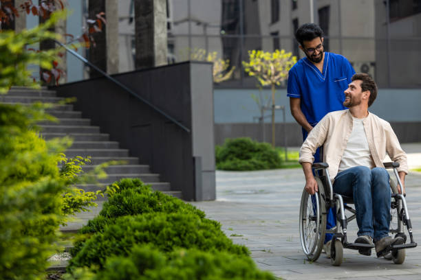 istock Male nurse rolling a wheelchair with patient and both feeling good 2012886269