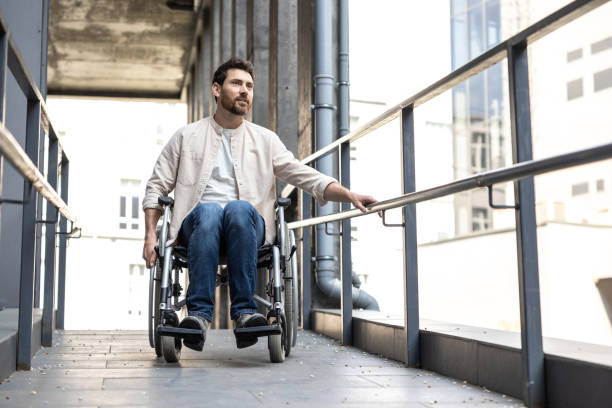 istock Dark-haired young caucasian man riding a wheelchair 2012887394
