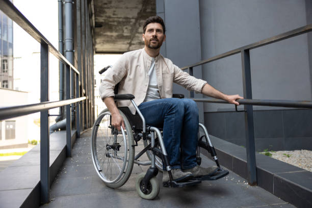 istock Dark-haired young caucasian man riding a wheelchair 2012887412