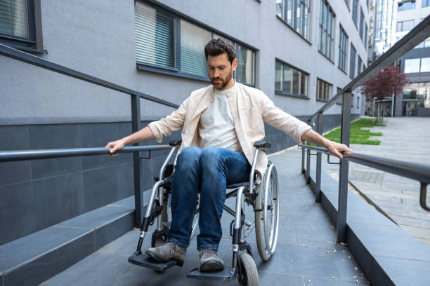 istock Disabled man on a wheelchair looking positive and smiling 2012887975
